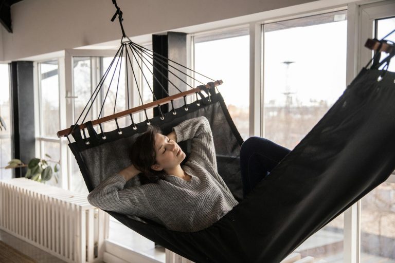 tired woman sleeping in cozy hammock in flat